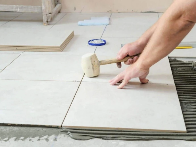 Pose de carrelage avec croisillons de nivellement sur un chantier à Salazie
